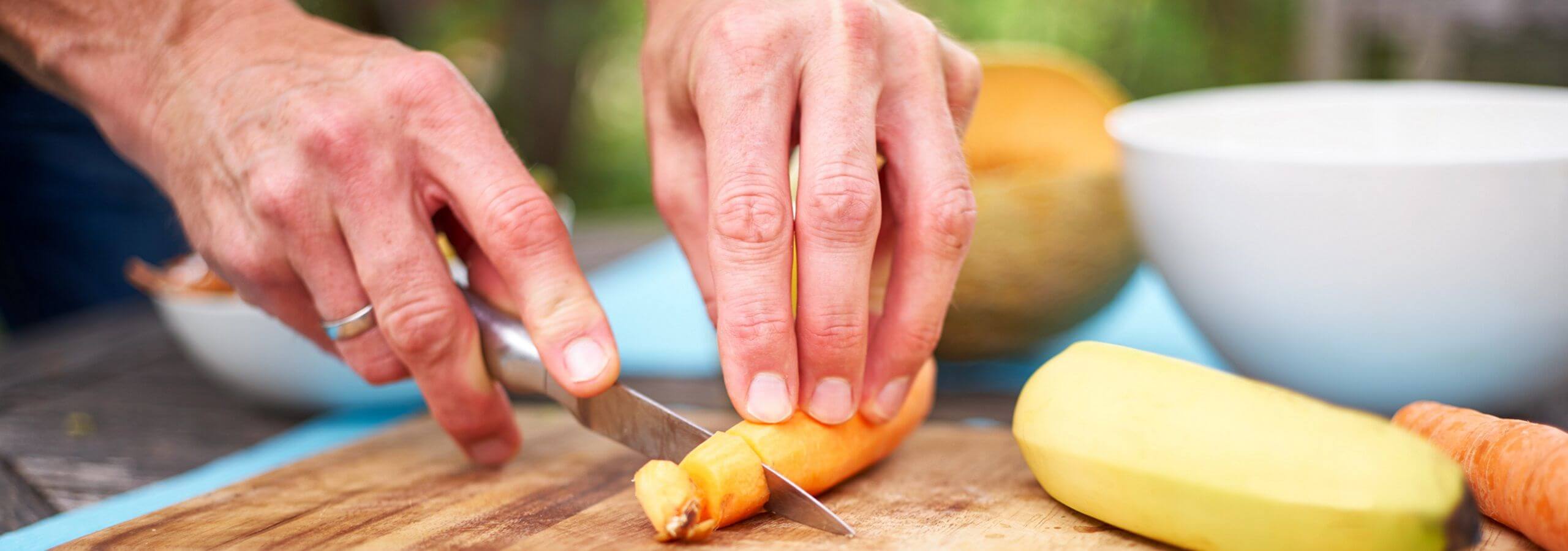 Mann schneidet eine Karotte