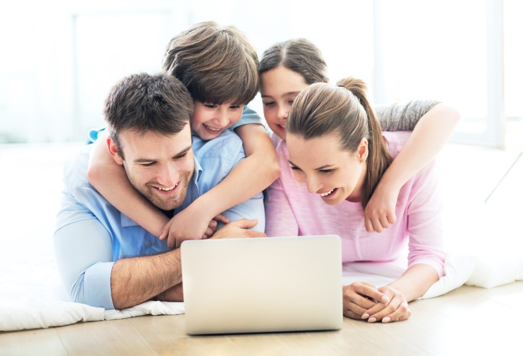 Mutter, Vater und zwei Kinder am Laptop.