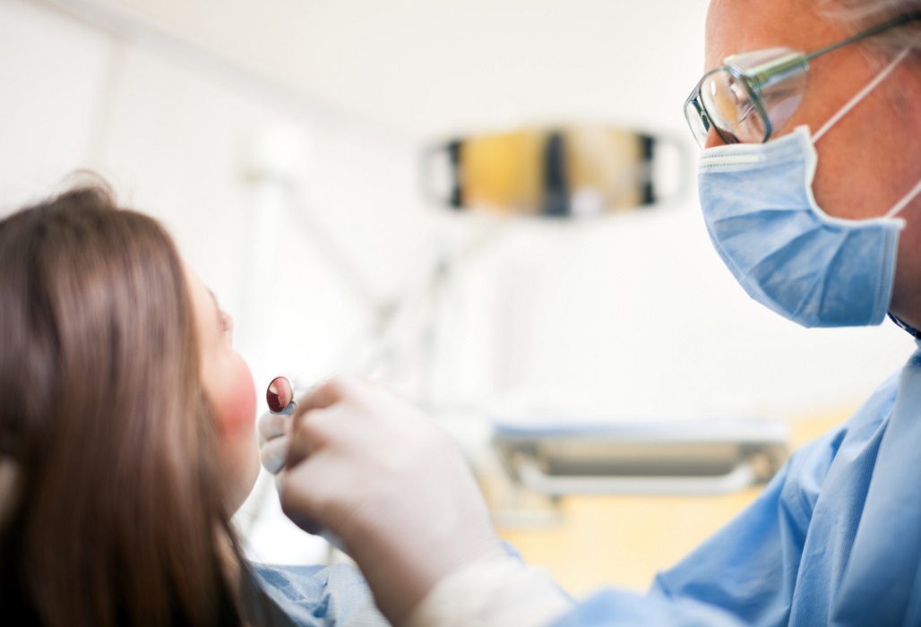 Zahnarzt untersucht eine Patientin.