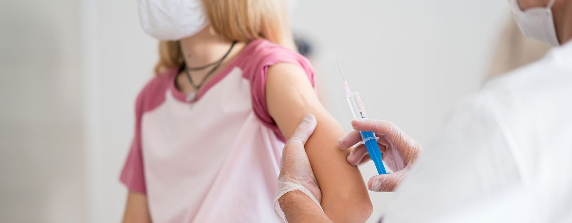Arm einer Jugendlichen kurz vor Impfung durch einen Arzt