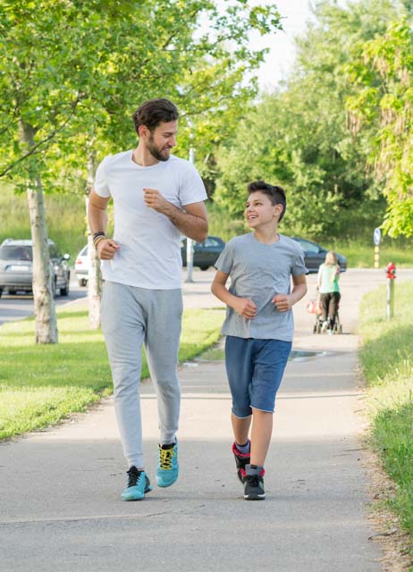 Jugendlicher joggt mit seinem Vater.