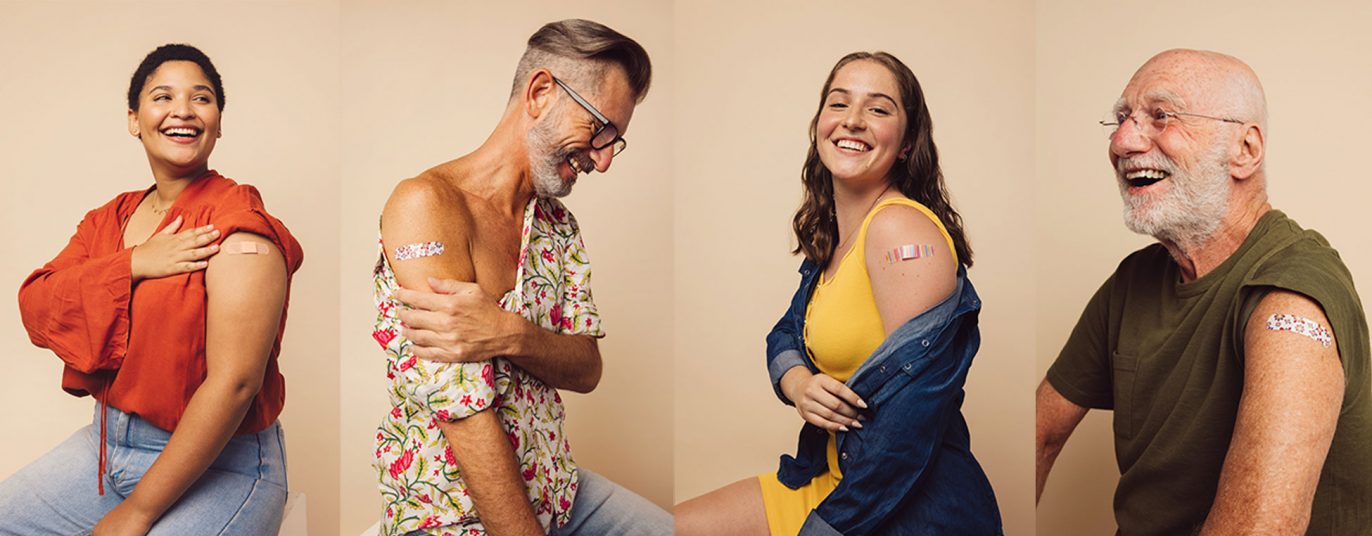 Lächelnde Leute nach einer Impfung zeigen ihr Pflaster