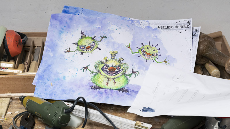 Gemalte Viren-Monster auf einem Blatt Papier in einer Werkstatt