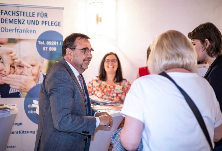 Bayerns Gesundheitsminister Klaus Holetschek unterhält sich mit Bürgerinnen bei der Veranstaltung 